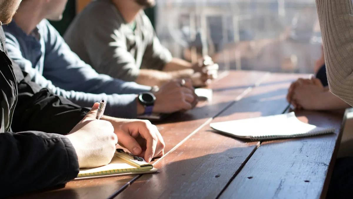 Team meeting around an office table with notebooks and pens