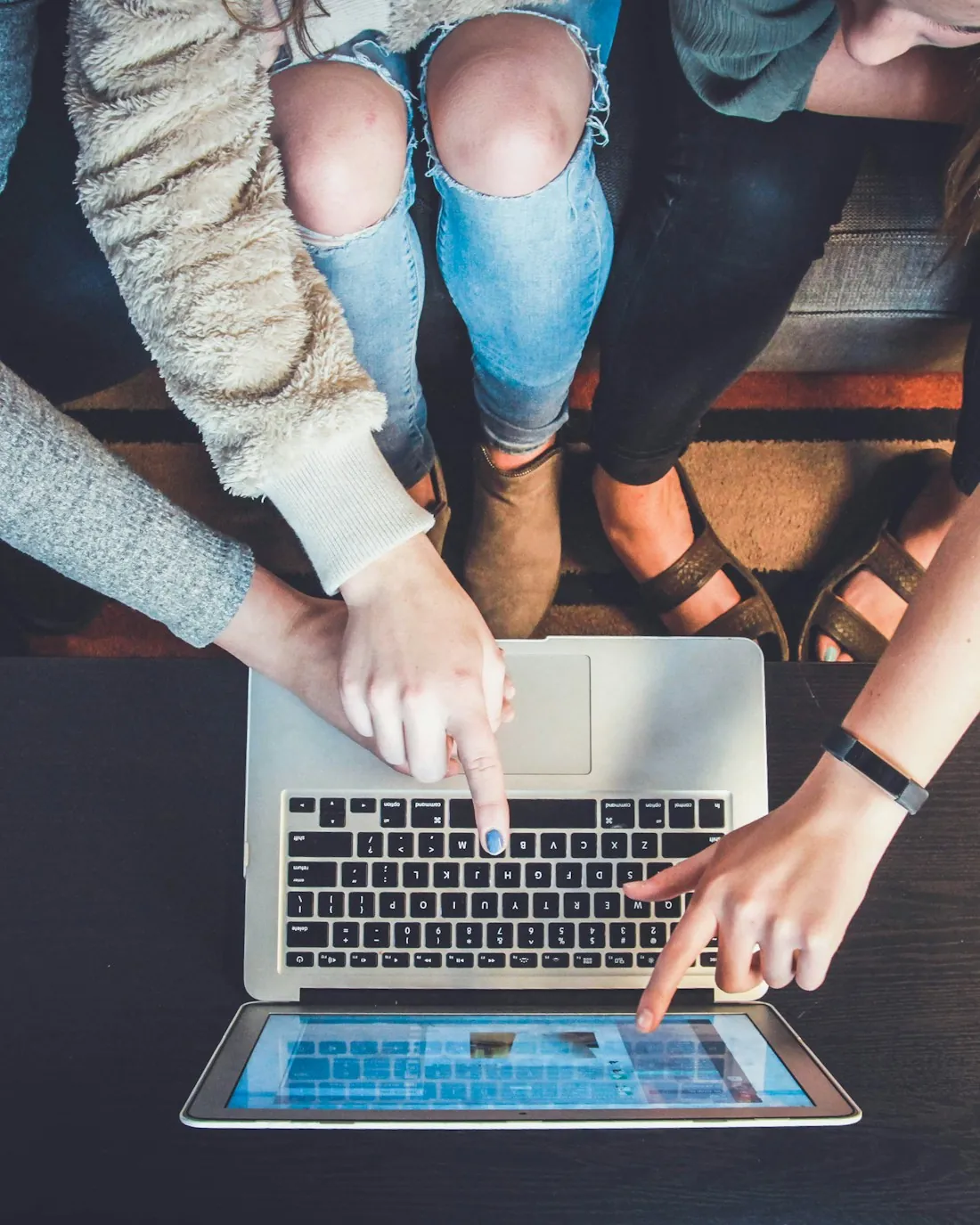 Team working together around a laptop &mdash; start your career in logistics support with Surya Rapaka System